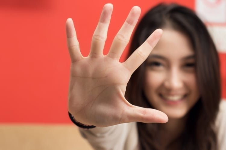 Young woman counting five on her fingers