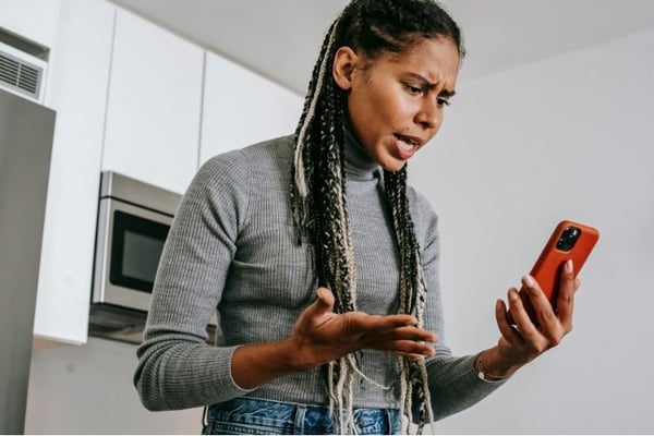Woman looking at her phone and feeling stressed out