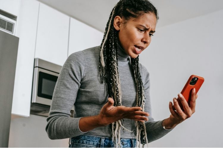 Woman looking at her phone and feeling stressed out